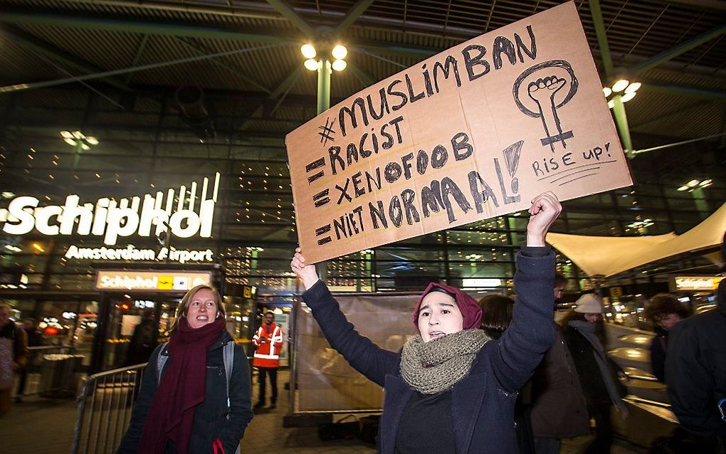 Demonstranten voor de hoofdentree van luchthaven Schiphol voeren actie tegen het besluit van president Donald Trump om vluchtelingen en inwoners van zeven islamitische landen niet meer toe te laten in Amerika. beeld ANP