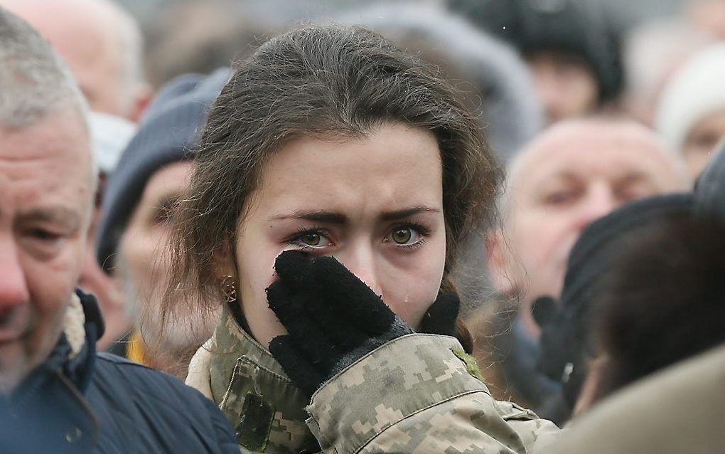 Een toeschouwer bij de uitvaart van zeven Oekraïense militairen in Kiev, woensdag. beeld EPA