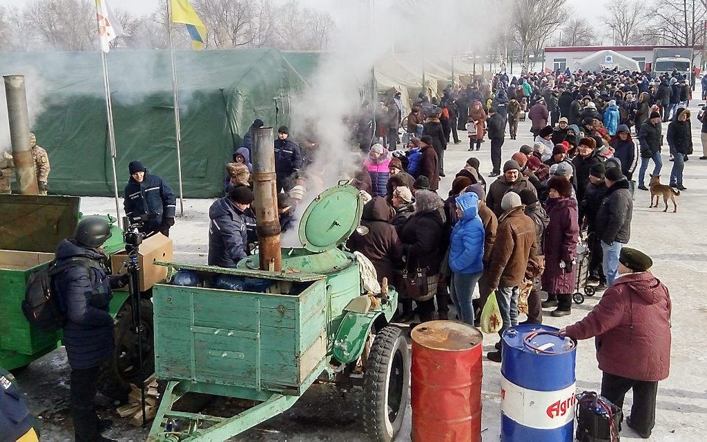 Militairen delen soep uit aan inwoners van de regio Donetsk. beeld EPA