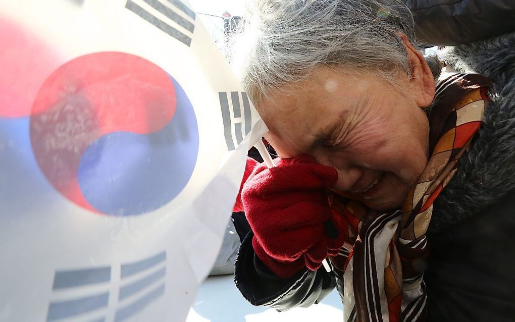 Een aanhanger van de afgezette president Park Geun-hye is aangedaan na de uitspraak van de rechter. beeld EPA