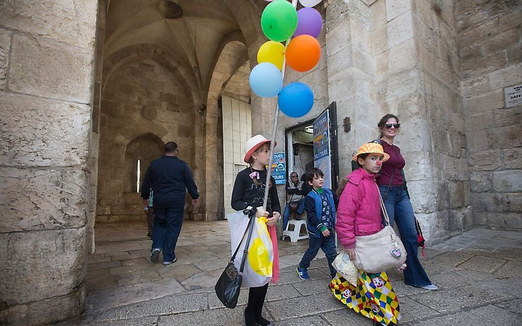 Uitgedoste Joodse kinderen lopen door de Jaffa-poort in Jeruzalem tijdens het Poerimfeest. Beeld EPA, Atef Safadi