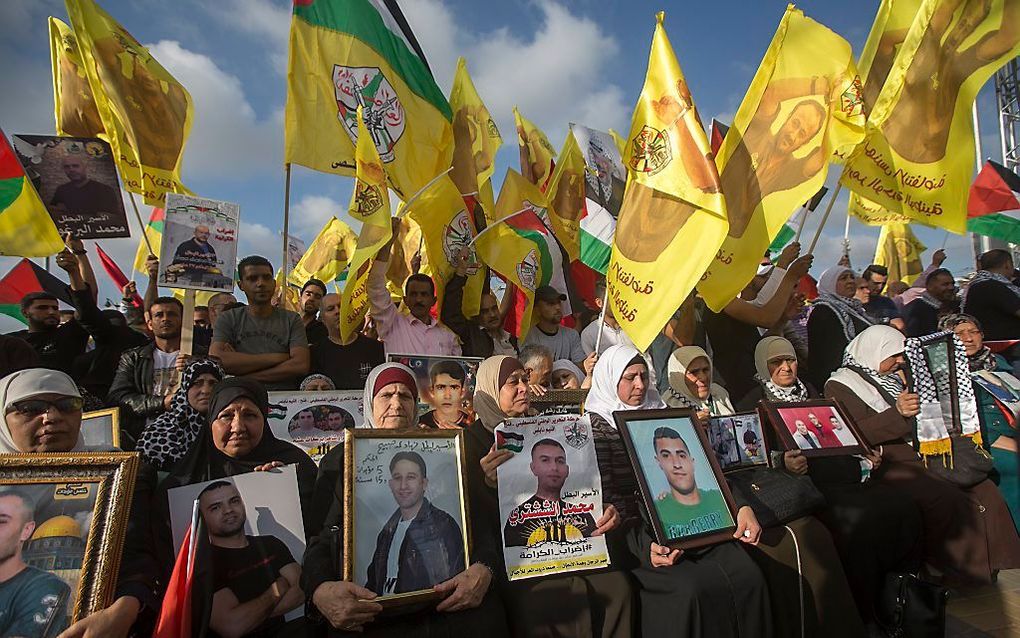 Palestijnse demonstraten met foto’s van familieleden die in Israëlische gevangenissen zijn opgesloten. beeld EPA