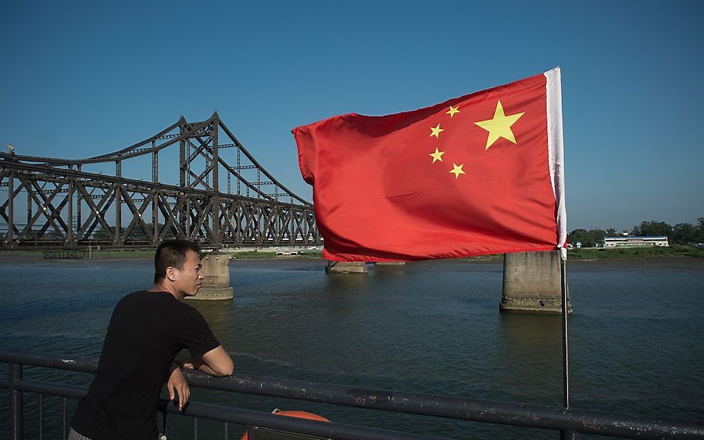 Een toerist kijkt uit over de Yalurivier die tussen Noord-Korea en China stroomt. beeld AFP