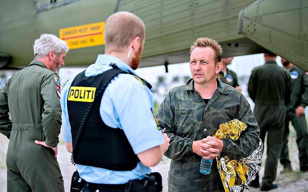 Peter Madsen praat met de politie na het zinken van zijn duikboot. beeld AFP