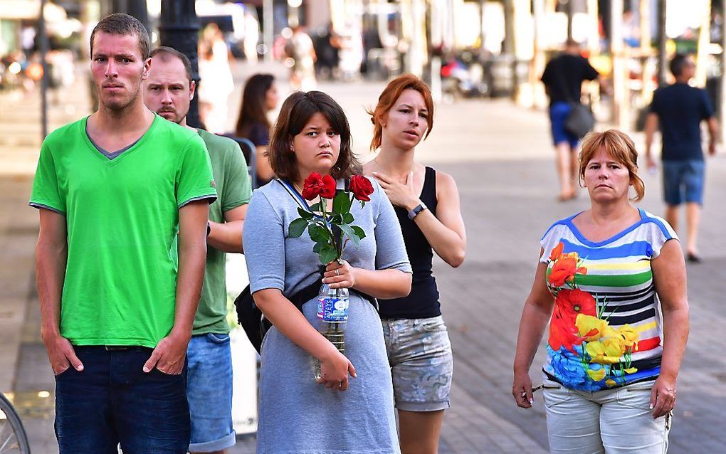 Een vrouw loopt met bloemen op de Ramblas na de aanslag in Barcelona. Een bestelbus reed in op voetgangers op Ramblas, een drukke promenade die populair is onder toeristen. beeld ANP