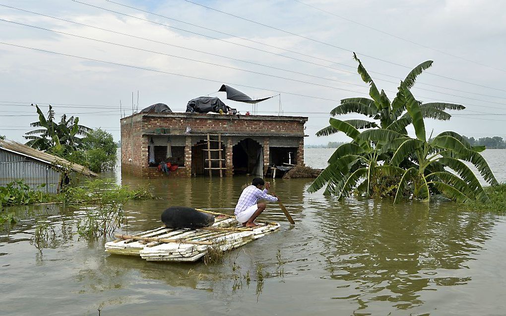 Een man uit India gebruikt een vlot om een veiliger heenkomen te zoeken. beeld AFP