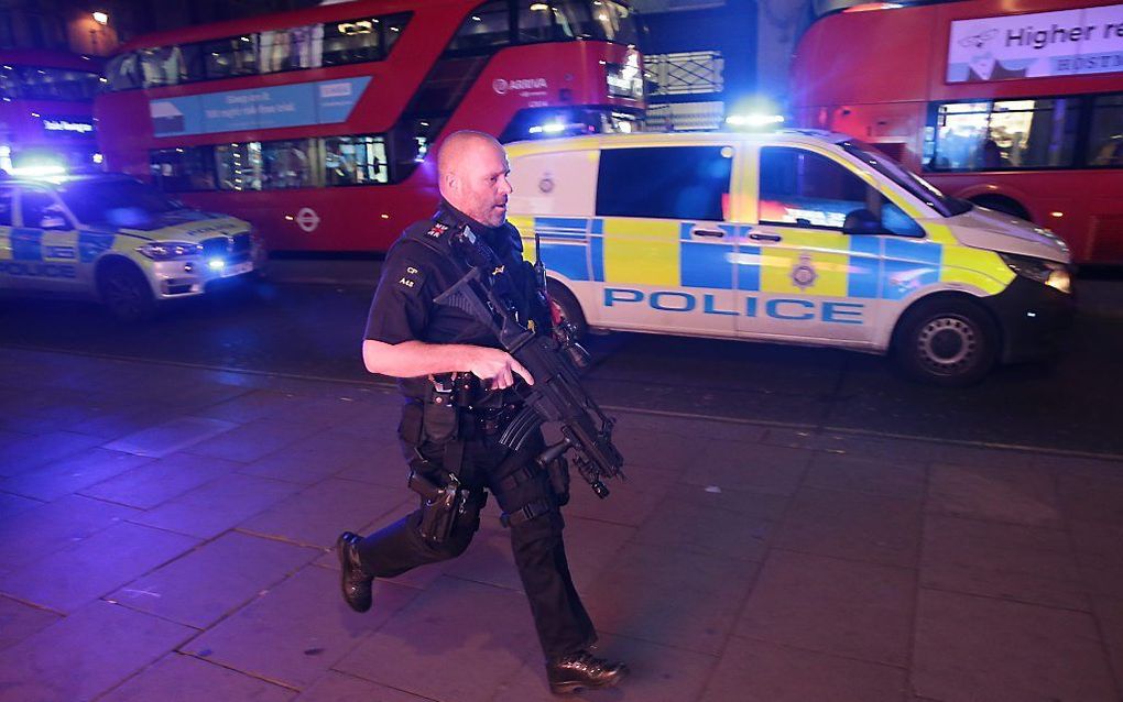 Een gewapende politieagent rent door Oxfordstreet. beeld AFP