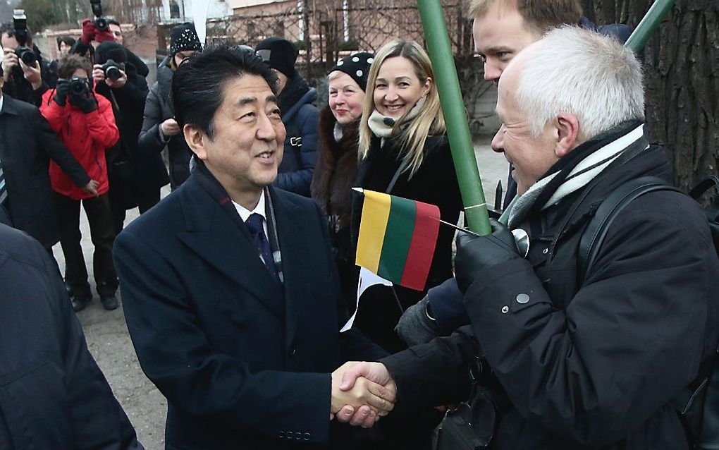 Premier Abe wordt begroet door omwonenden van het Sugiharahuis in Kaunas. beeld AFP