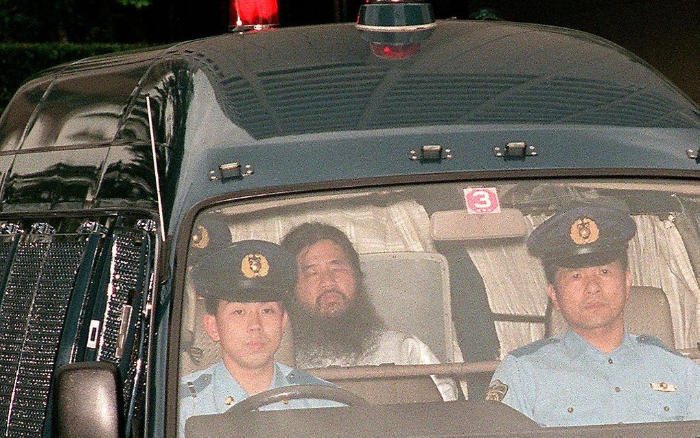 Shoko Asahara (m), leider van de sekte Aum Shinrikyo, heeft het politiebureau verlaten. beeld AFP