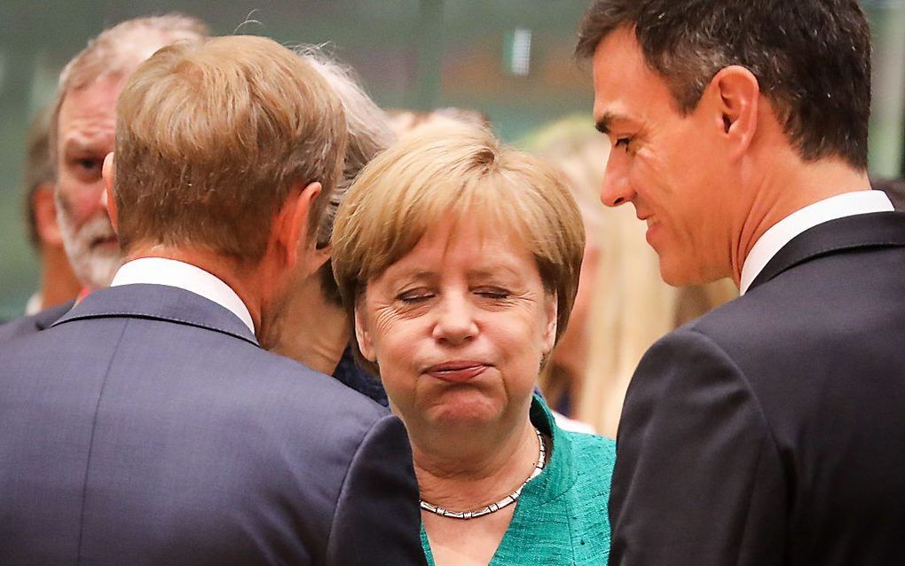 Merkel in gesprek met Donald Tusk (l.) en de Spaanse premier Pedro Sanchez. beeld AFP