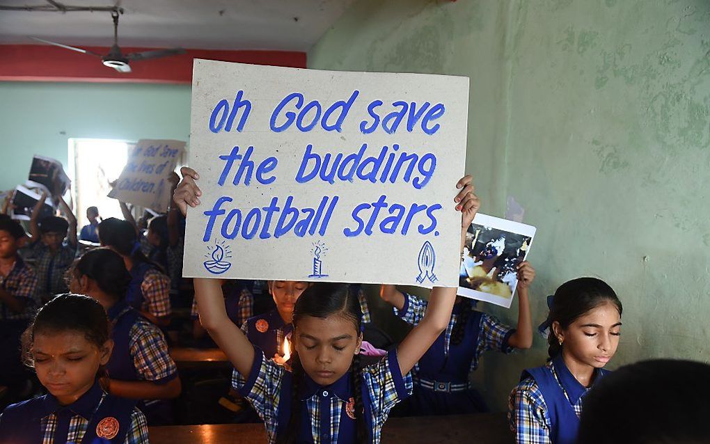 Gebed op een school in Thailand voor de jongens die nog vastzitten in een grot. beeld AFP