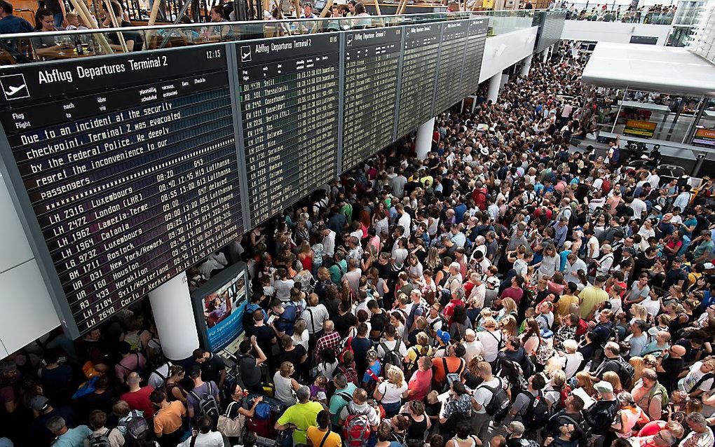 Honderden passagiers wachten in terminal 2 van de luchthaven van München. beeld EPA