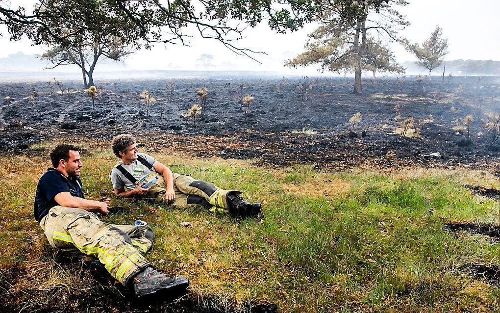 Brandweerlieden rusten uit na het blussen van een natuurbrand in Drenthe, augustus 2018. beeld ANP