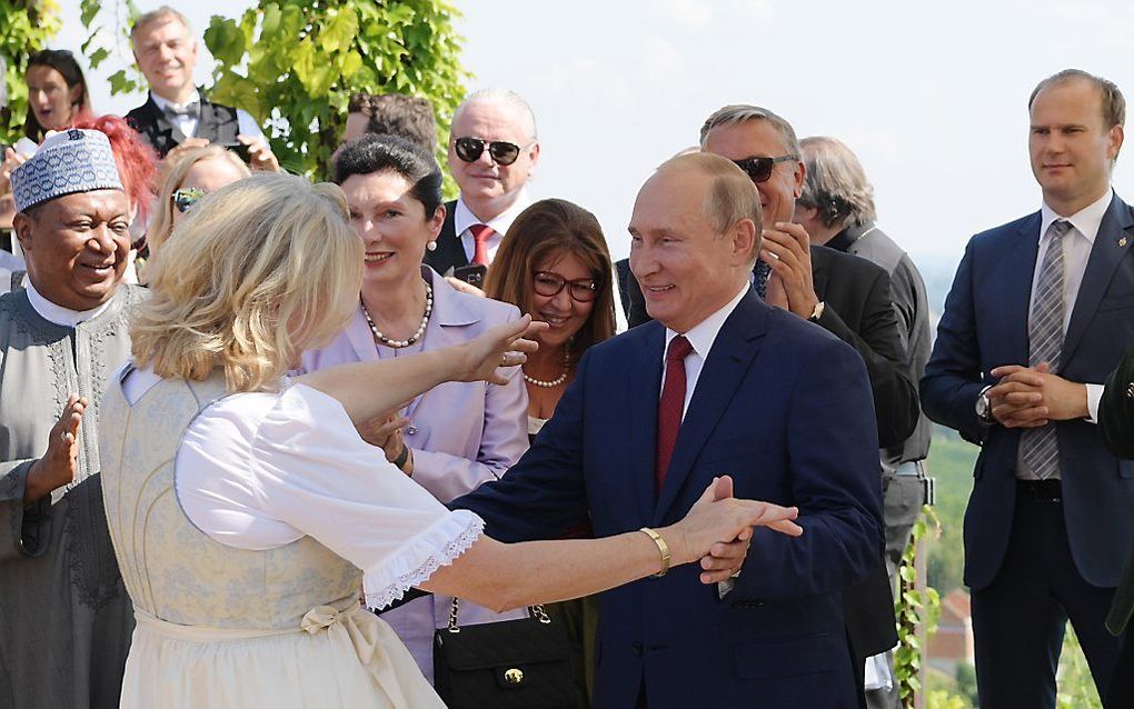 De Russische president Vladimir Poetin en de Oostenrijkse minister Karin Kneissl (Buitenlandse Zaken). beeld EPA