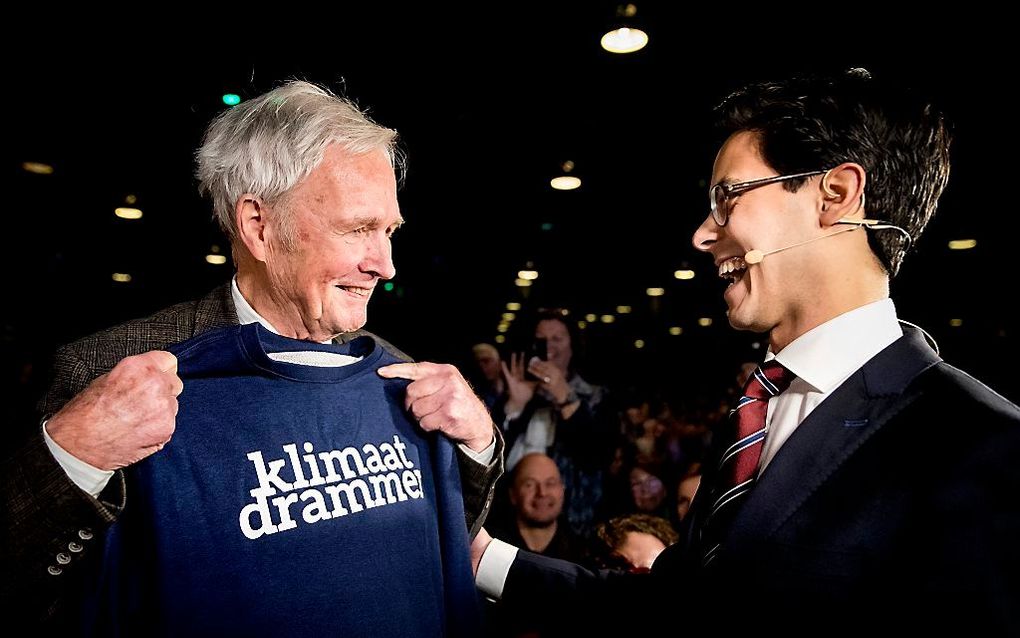 Fractievoorzitter Tweede Kamer Rob Jetten (R) biedt Jan Terlouw een klimaatdrammertrui aan tijdens het 109e partijcongres van D66. beeld ANP