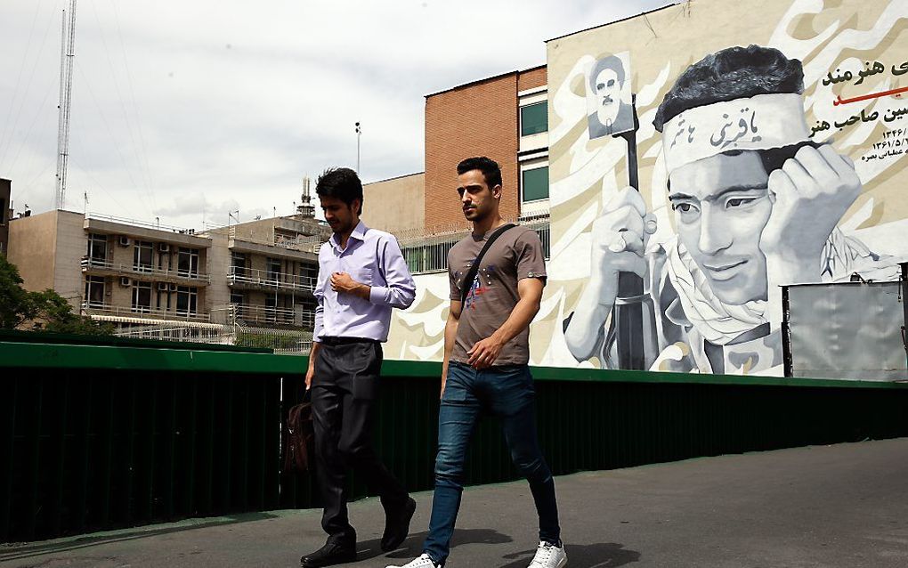 Iraniërs passeren een muurschildering in Teheran. beeld EPA