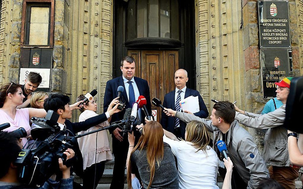 Advocaten van de kapitein staan de pers te woord voor de rechtbank in Boedapest. beeld AFP