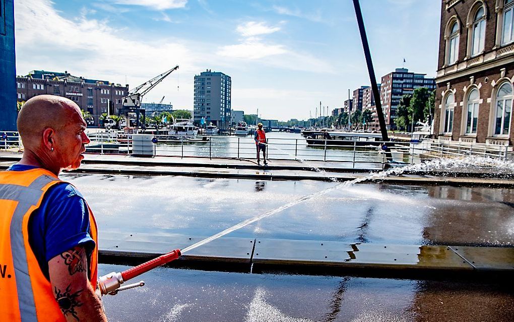 De Binnenhavenbrug in stadsdeel Feyenoord wordt natgehouden door medewerkers van de gemeente. De gemeente probeert hiermee te voorkomen dat stalen constructies teveel uitzetten door de warmte en daardoor klem komen te zitten. beeld ANP