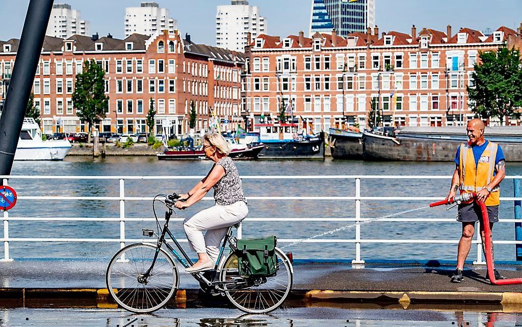 De Binnenhavenbrug in stadsdeel Feyenoord wordt natgehouden door medewerkers van de gemeente. De gemeente probeert hiermee te voorkomen dat stalen constructies teveel uitzetten door de warmte en daardoor klem komen te zitten. beeld ANP