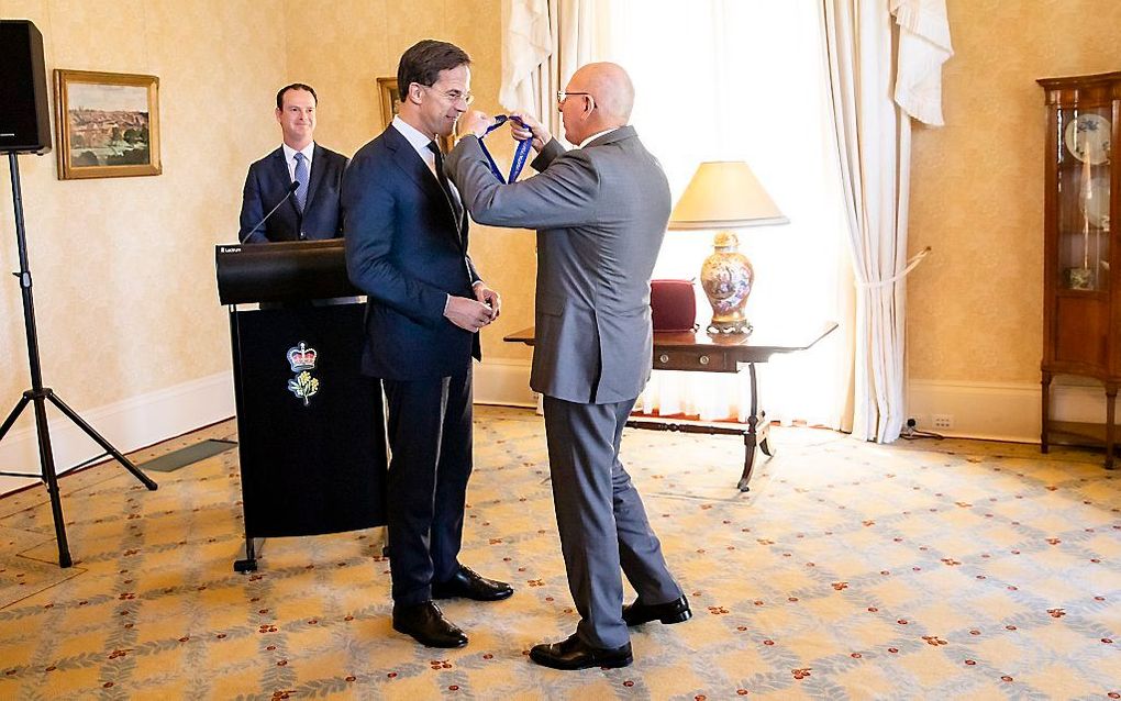 Premier Mark Rutte krijgt een onderscheiding uit handen van Gouverneur Generaal David Hurley. Premier Mark Rutte ontvangt de Honorary Companion of the Order of Australia vanwege zijn inzet na het neerhalen van vlucht MH17. Premier Mark Rutte brengt een dr