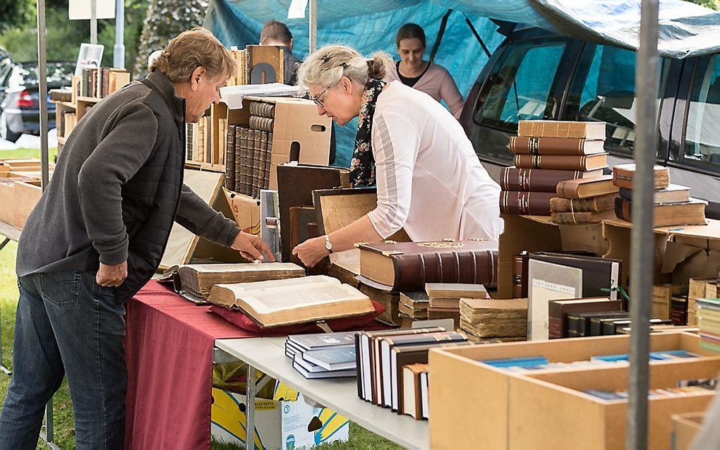 Peter van der Schelde, uitgever bij Importantia in Dordrecht, gaat oude theologische werken inscannen en als pdf-download aanbieden. Foto: theologische boeken op de Elspeetse boekenmarkt, deze zomer. beeld André Dorst