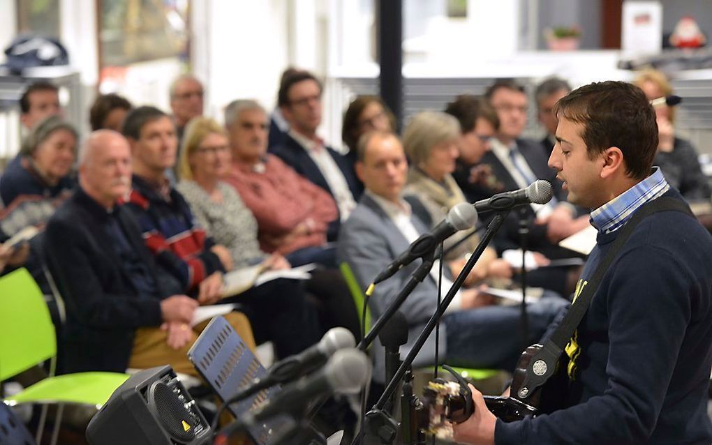 Geldermalsen. Tijdens een interkerkelijke bijeenkomst na de rellen in Geldermalsen zingt de christelijke asielzoeker Firas Lumsden Psalm 40 in het Arabisch.  beeld William Hoogteyling