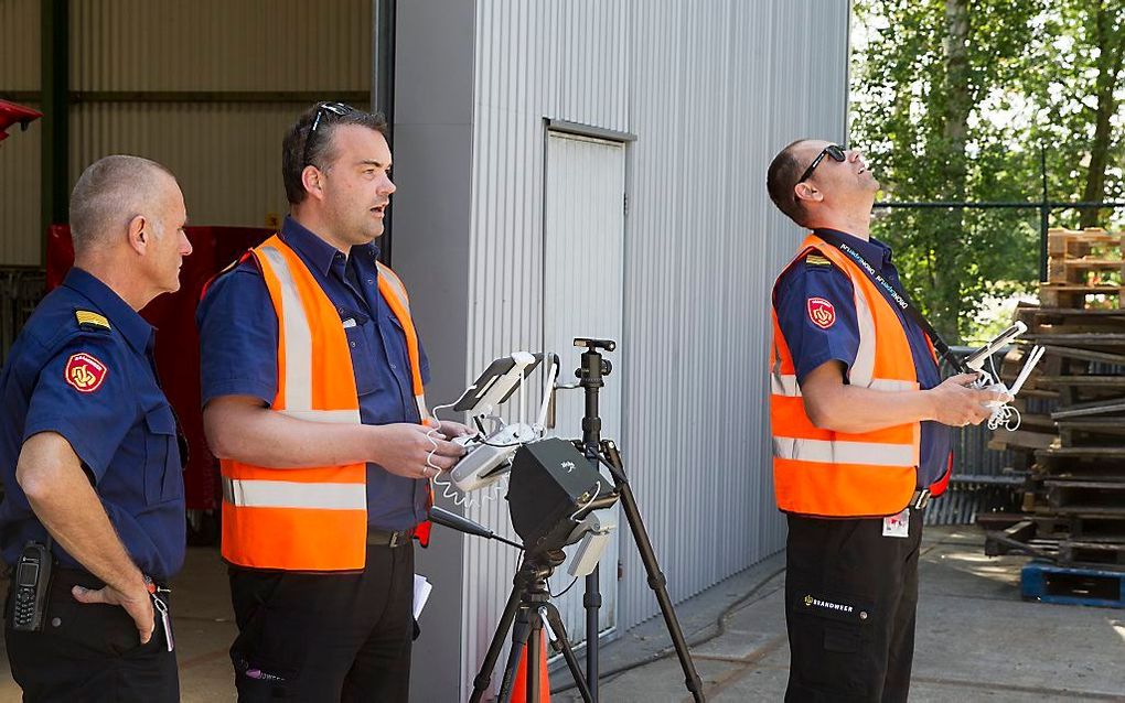 Brandweerlieden trainen op Enschede Airport Twente met een drone. De brandweer gaat de luchtvaartuigjes binnenkort ook 's nachts inzetten. beeld RD, Anton Dommerholt