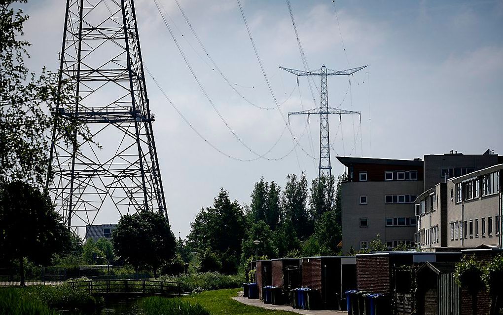 Hoogspanningsmasten bij een woonwijk in Sliedrecht. beeld ANP, Robin van Lonkhuijsen