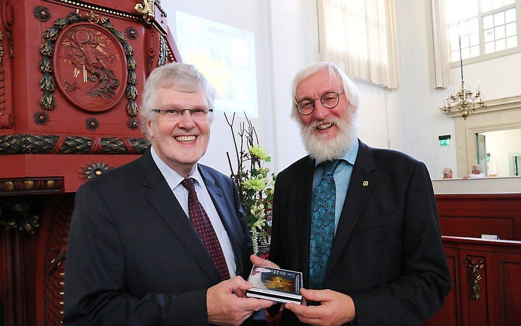 Ronald de Jong (r.) krijgt een dubbel-cd uit handen van van Piet Lindenberg. beeld Conno Bochoven