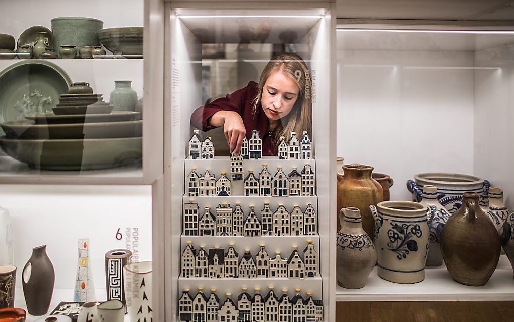 1.	Conservator Eline van den Berg plaatst de KLM huisjes in de vitrine. beeld Lucas Kemper