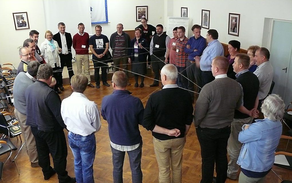 Bij de behandeling van de vraag “Waarom wordt gij een christen genaamd?” zijn de deelnemers van de conferentie met een draad aan elkaar verbonden. beeld RD