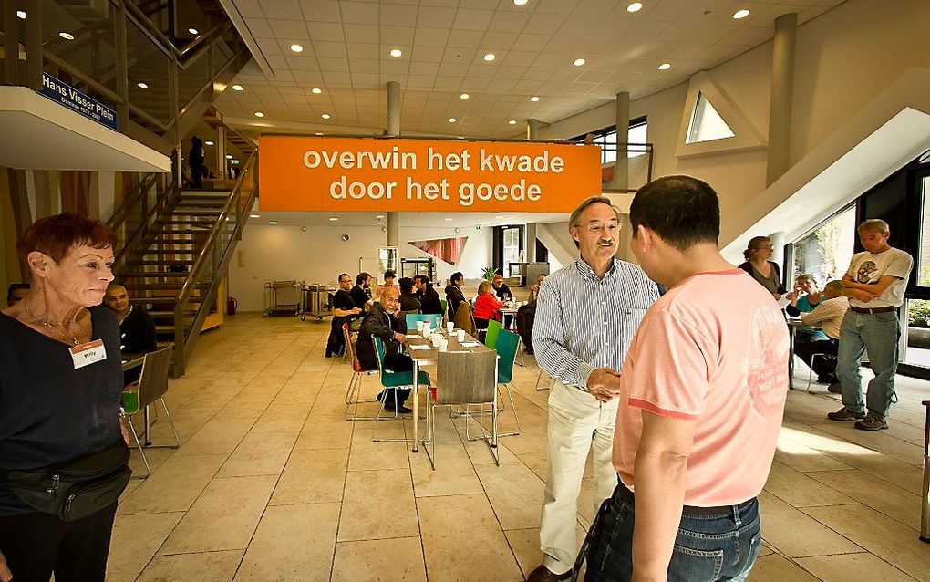 Ds. D. J. Couvée begroet een bezoeker van de Pauluskerk in Rotterdam. Hij vindt het opvallend dat veel Rotterdammers blijkens onderzoek bereid zijn te helpen bij de aanpak van dakloosheid. .beeld RD, Henk Visscher