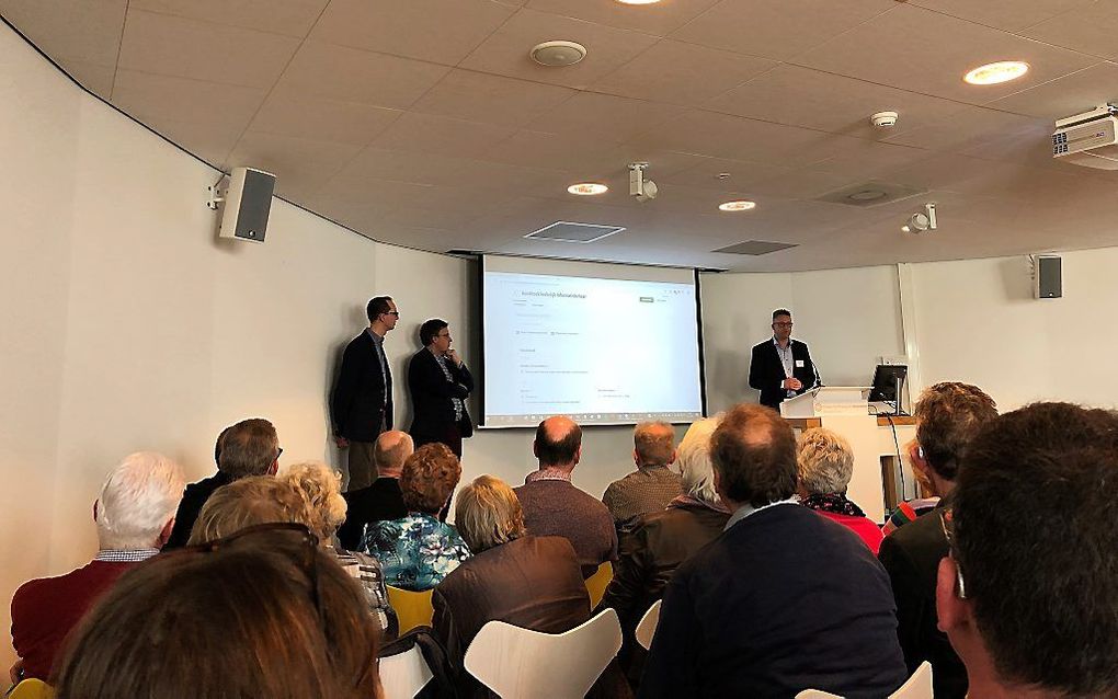 Timo van Houdt (r.) en Anthony van der Wulp (l.) presenteren het ”Handboek kerkelijk informatiebeheer”. In het midden prof. dr. Fred van Lieburg. beeld RD