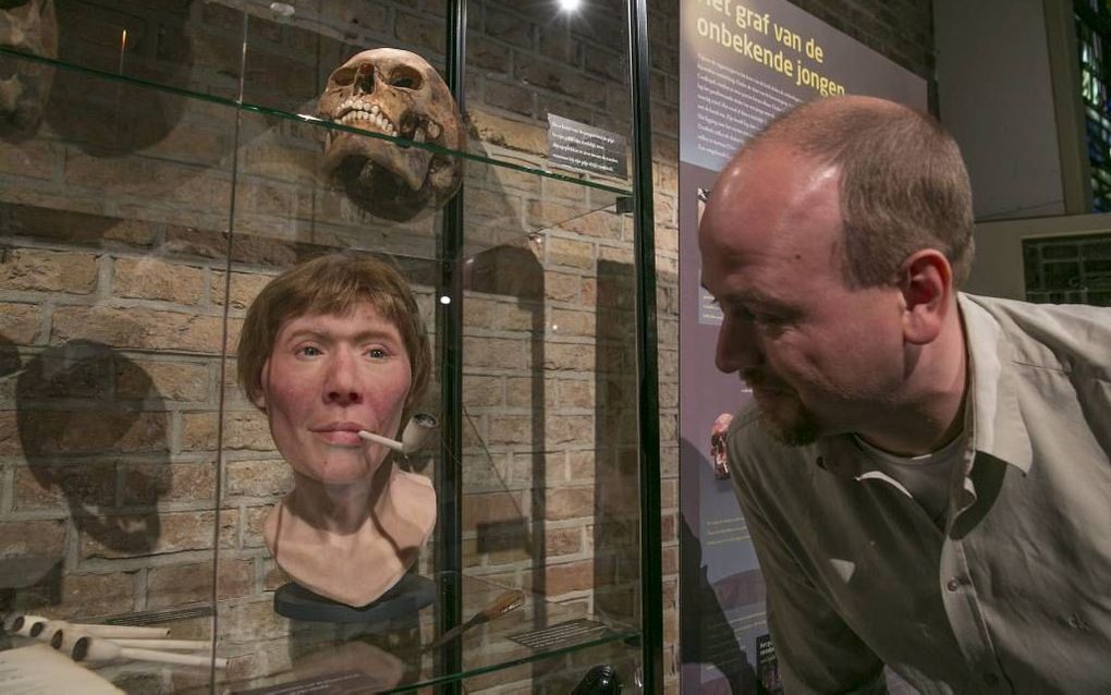 GOUDA. De schedel van straatjongen ”Jacob” is met een reconstructie van zijn gezicht tentoongesteld in de Sint-Janskerk in Gouda, samen met andere vondsten uit opgegraven grafkelders. Rechts de Goudse stadsarcheoloog Maarten Groenendijk.  beeld Martin Dro