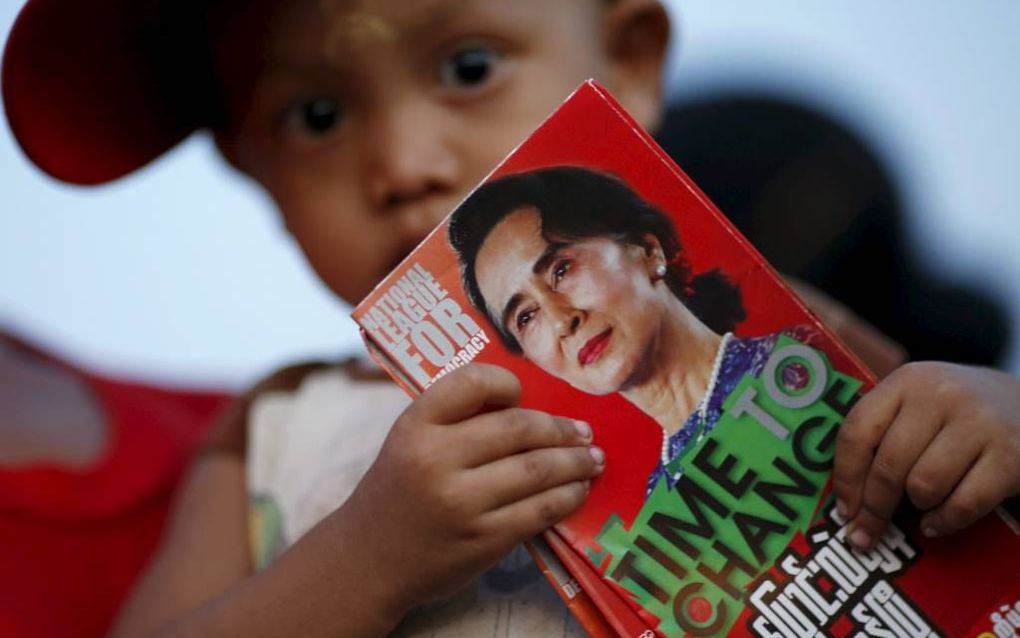 Een jochie houdt een folder vast van de Birmese oppositieleider Aung San Suu Kyi, die morgen voor haar partij meedoet aan de verkiezingen. In 1990 won ze ook al de verkiezingen, maar werd toen gevangen gezet. Het zijn nu de eerste vrije verkiezingen in 25