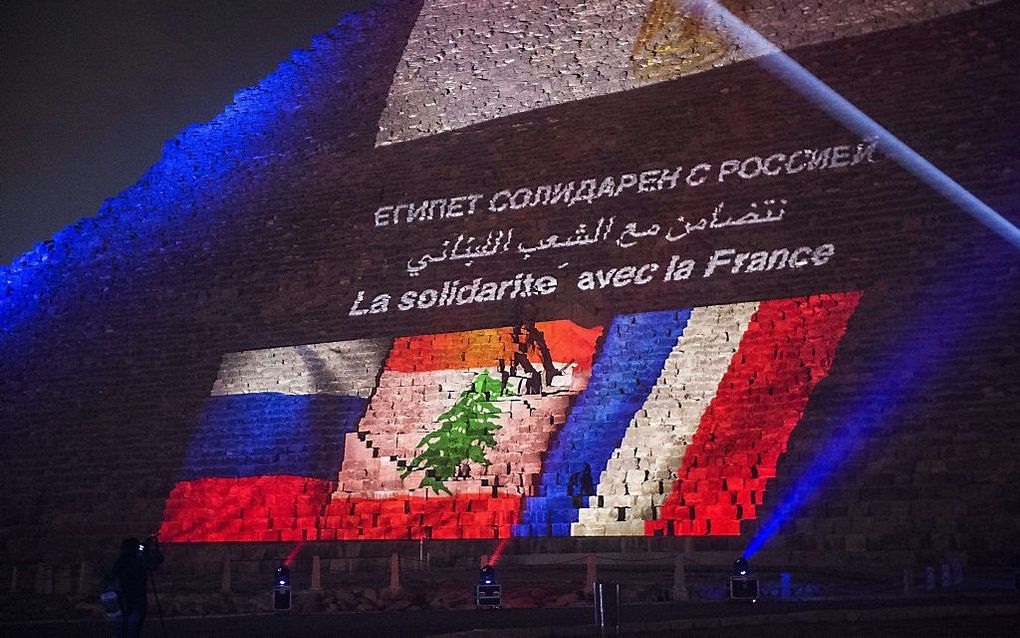 De piramide van Cheops is verlicht met de Franse, Libanese en Russische vlag. beeld AFP