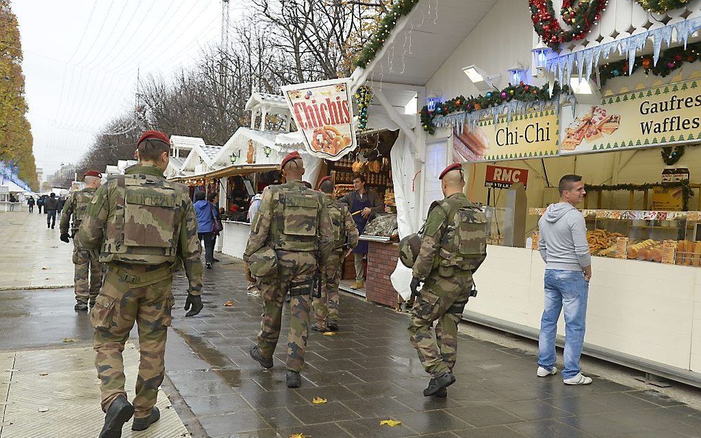 Gewapende Franse militairen op de kerstmarkt op de Champs-Elysees in Parijs. beeld AFP