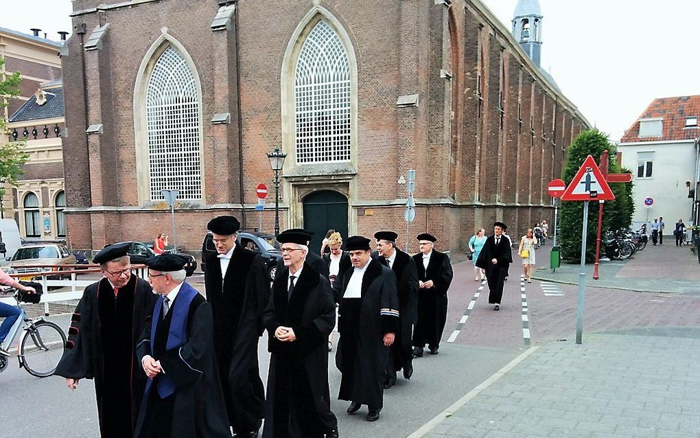 Hoogleraren van diverse theologische universiteiten verlaten de Broederkerk in Kampen, na een academische plechtigheid in juni 2015.  beeld RD