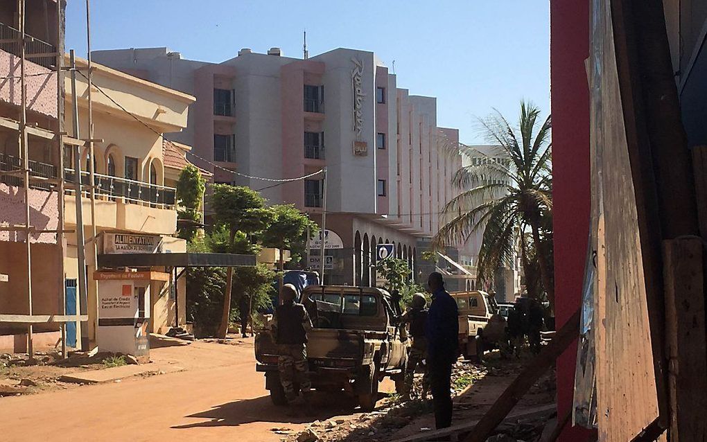 Militairen nemen posities in in de buurt van het Radisson Blu Hotel in Bamako. Daar worden zo'n 170 mensen in gijzeling gehouden. beeld AFP