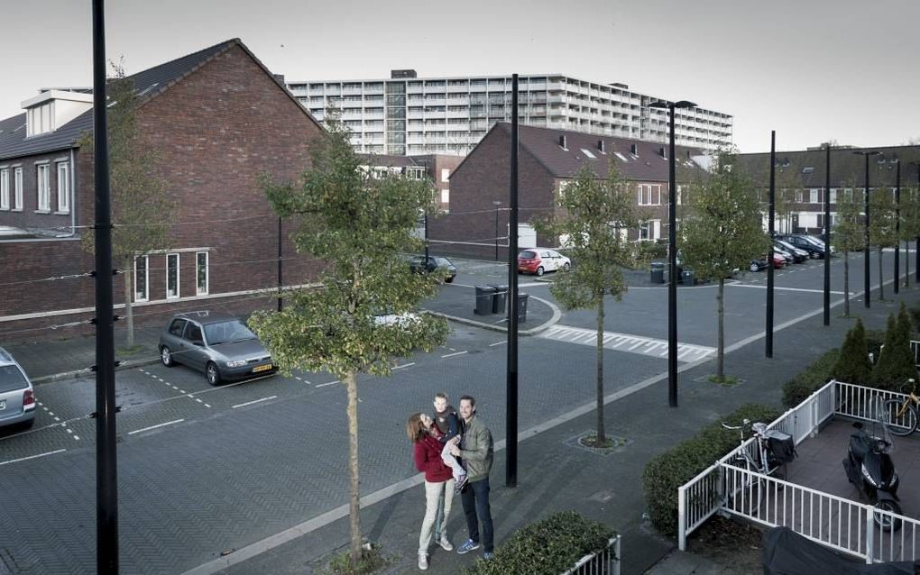 Michiel en Marjon van Dijken met hun zoon Jesse voor hun huis in een nieuwbouwgedeelte in de Bijlmer. beeld Sjaak Verboom