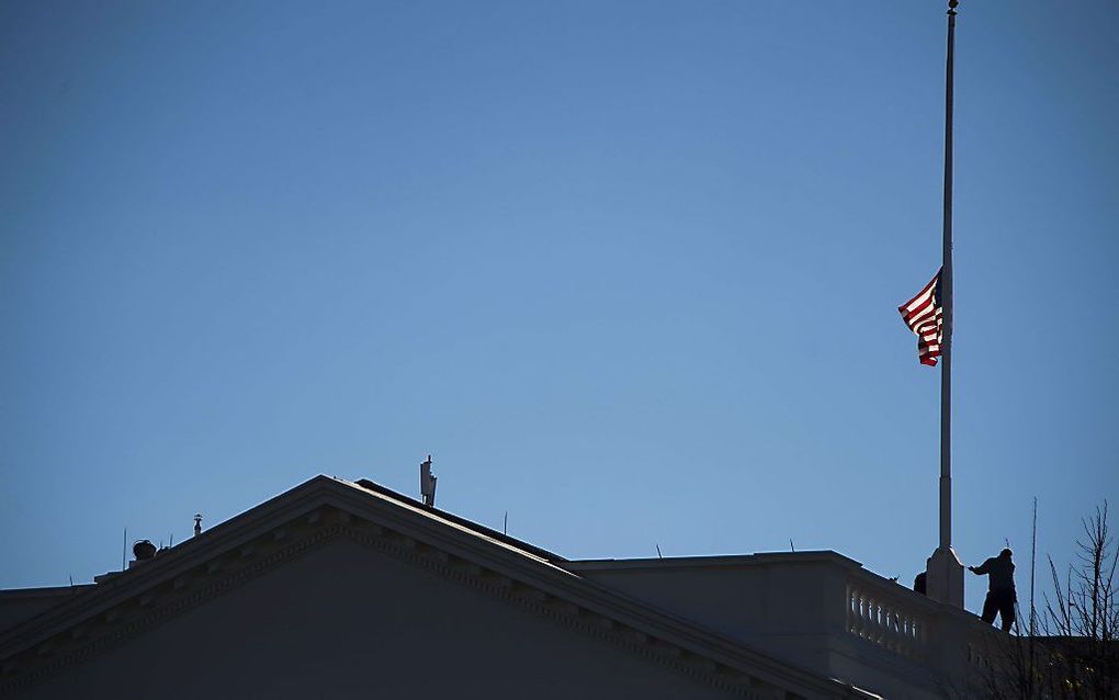 De vlag op het Witte Huis wordt na de schietpartij van woensdag halfstok gehangen. Beeld AFP