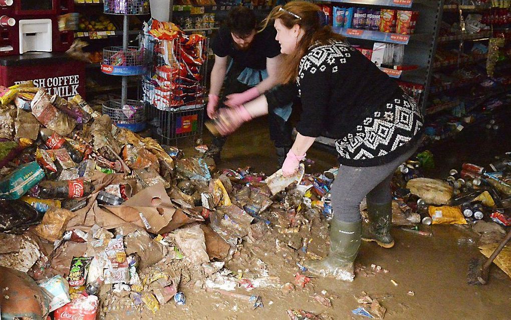 Medewerkers van een winkel in Cockermouth, in het noorden van Engeland, maandag. beeld AFP