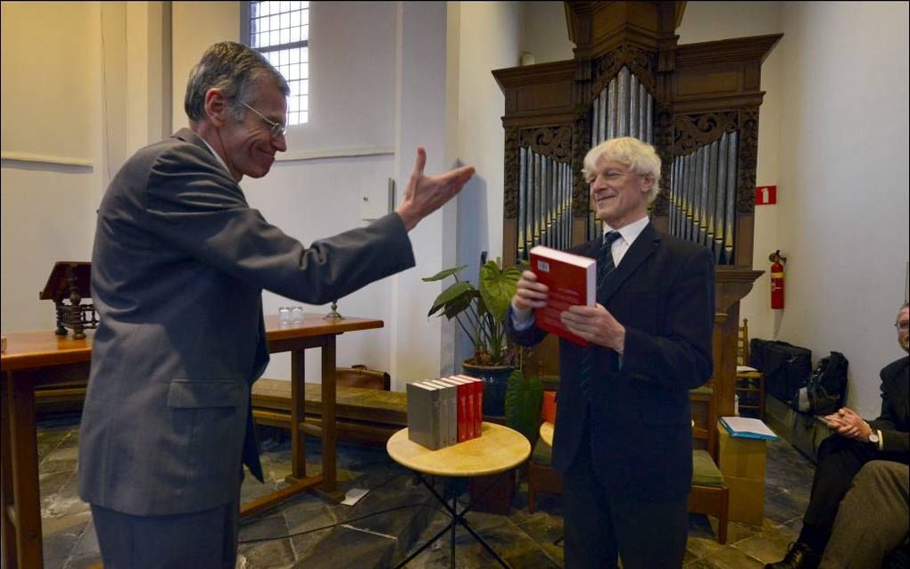 rof. dr. J. Muis, voorzitter van de Stichting Heruitgave Oudere Ethische Theologie, overhandigt het derde deel van het verzameld werk van J. H. Gunning jr. aan een van de mede-oprichters van de stichting dr. F. G. M. Broeyer. beeld Ton Borsboom