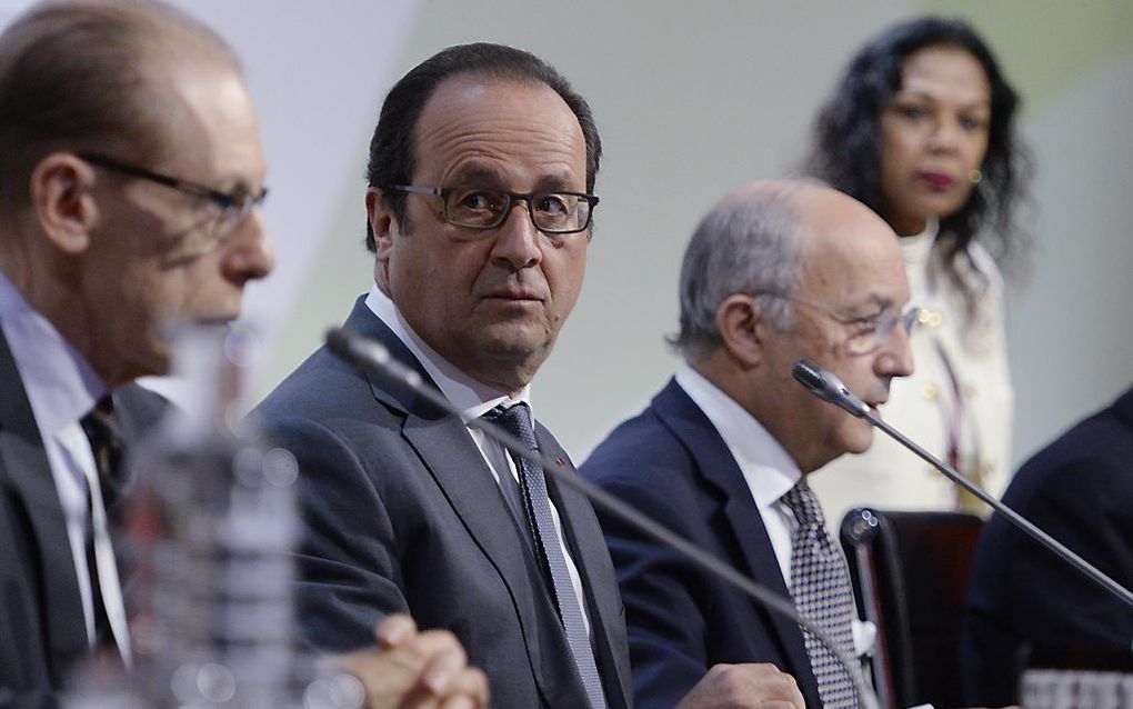 In aanwezigheid van de Franse president François Hollande heeft de Franse minister van Buitenlandse Zaken Laurent Fabius het ontwerp voor een internationaal klimaatakkoord voorgelegd. beeld AFP