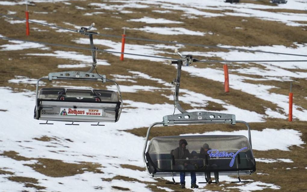 In Parijs hebben zaterdag 195 landen een klimaatakkoord gesloten. Dit moet voorkomen dat de aarde te veel opwarmt. Foto: Toeristen passeren dunne resterende sneeuwlaagjes op de skipiste van Feldberg in Duitsland, met 1493 meter de hoogste berg van het Zwa