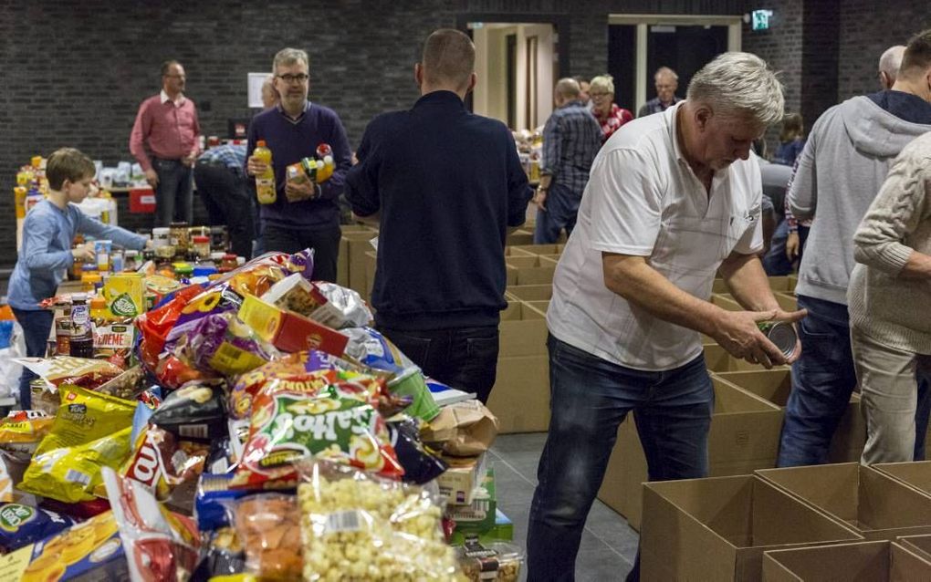 In kerkgebouw De Regenboog in Harderwijk vullen vrijwilligers 150 dozen met levensmiddelen. De diakenen delen deze uit aan mensen met een krappe beurs. beeld André Dorst