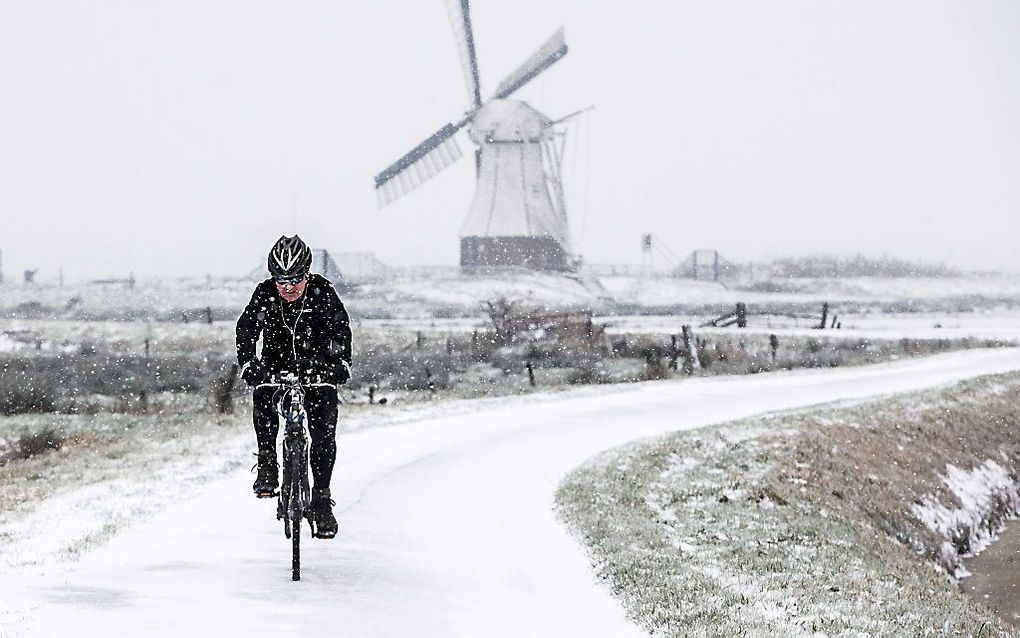 Een fietser in het winterse landschap van de Glimmense polder, in Groningen. Op de achtergrond De Witte Molen uit 1892 aan het Noord-Willemskanaal. beeld ANP