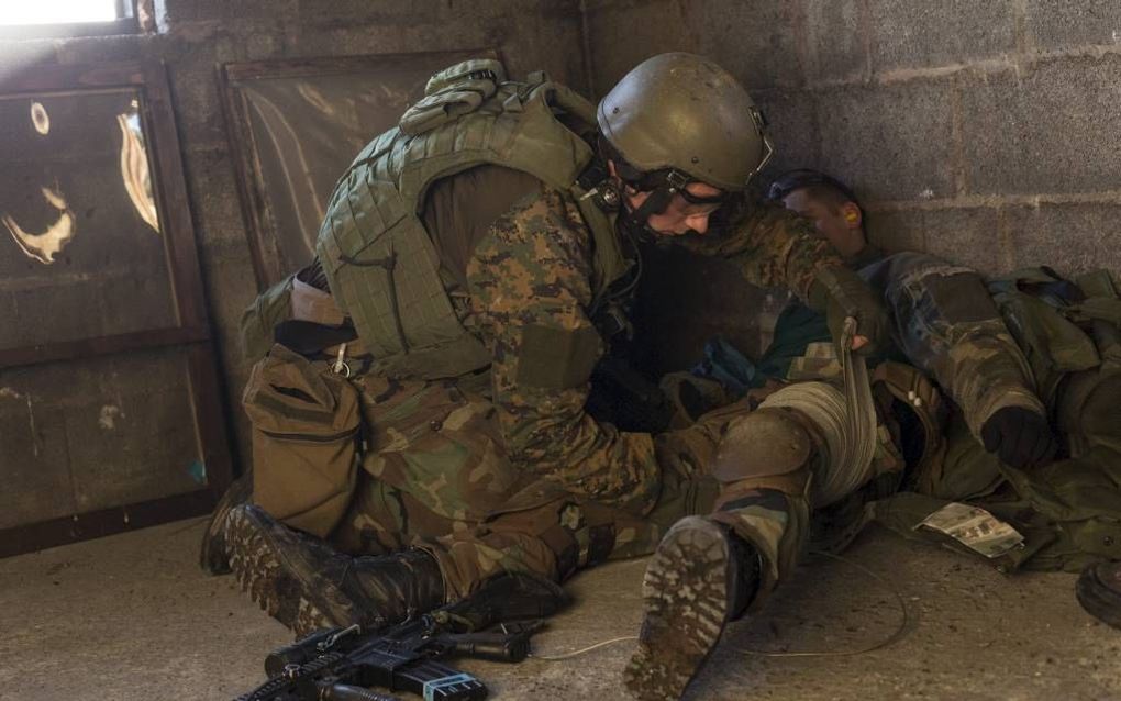 Een marinier verzorgt zijn gewond geraakte collega tijdens een oefening met scherp schieten op de Truppenübungsplatz in Duitsland. beeld André Dorst