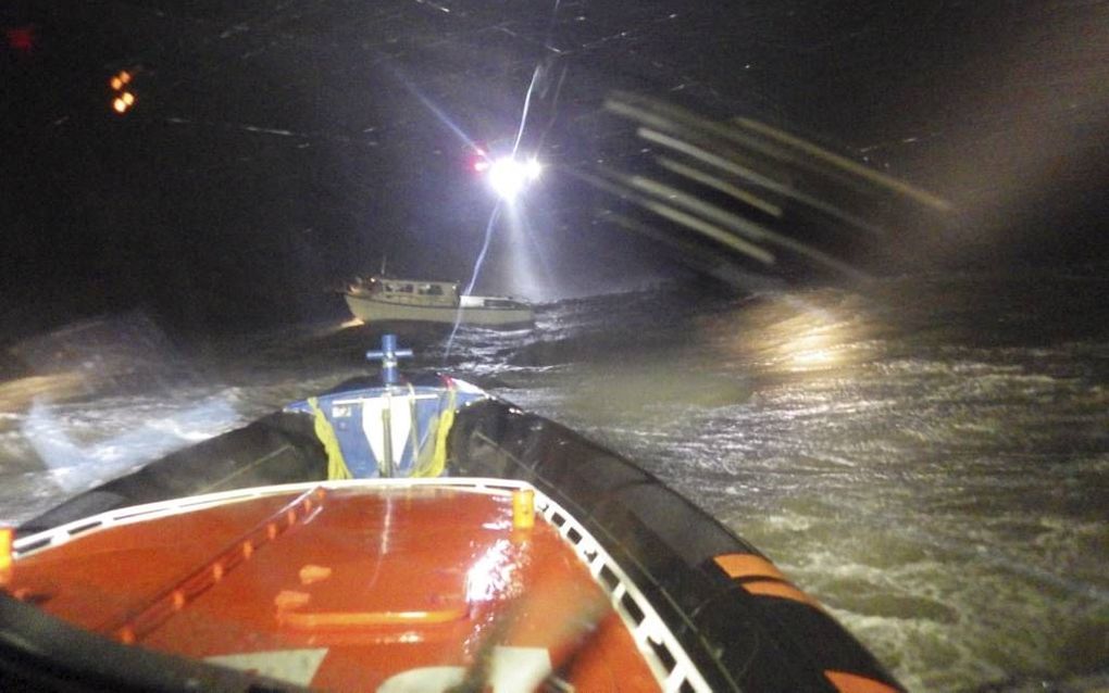 Een boot van vier sportvissers drijft stuurloos op de golven. Op de voorgrond de KNRM-reddingsboot uit Breskens. beeld KNRM