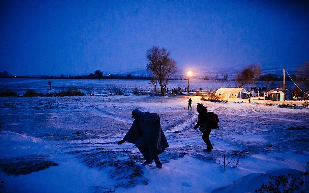 Migranten lopen door de sneeuw bij de grens tussen Servië en Macedonië. Beeld AFP